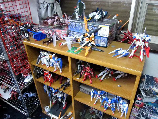 A photo of some of the demolished anime collection. Most of the Gundam pieces can be see knocked over or in pieces.